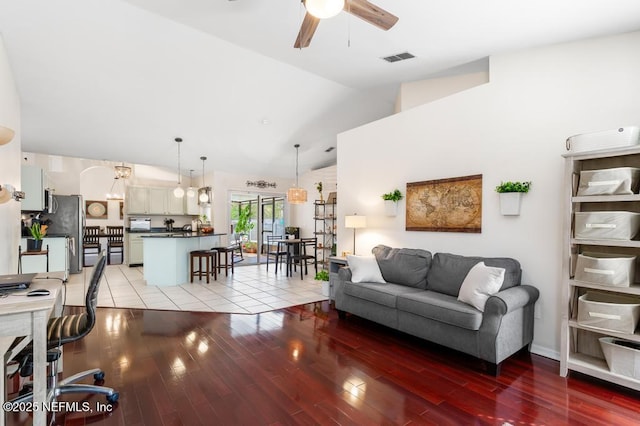 living room featuring vaulted ceiling, light hardwood / wood-style floors, and ceiling fan