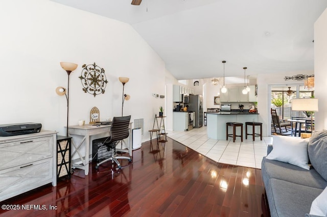 home office featuring vaulted ceiling, ceiling fan, and light wood-type flooring