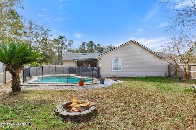 view of swimming pool featuring a yard and a fire pit