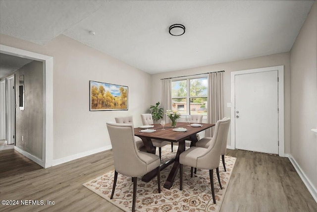 dining space featuring lofted ceiling and hardwood / wood-style floors