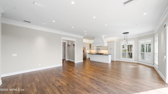 unfurnished living room with crown molding, a chandelier, and hardwood / wood-style flooring