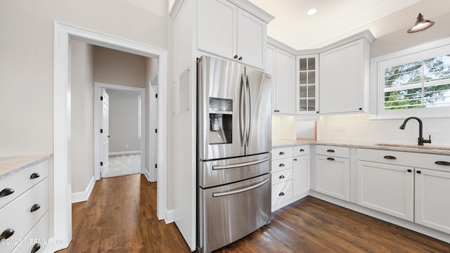 kitchen with white cabinetry, light stone countertops, and stainless steel fridge