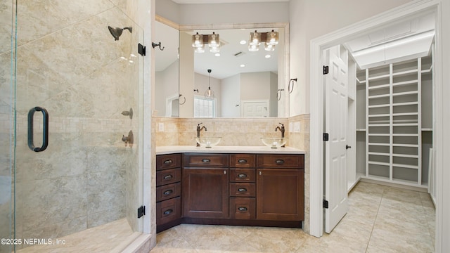 bathroom featuring vanity, an enclosed shower, and decorative backsplash