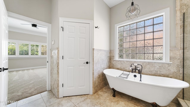 bathroom with tile patterned floors, a bathtub, and tile walls