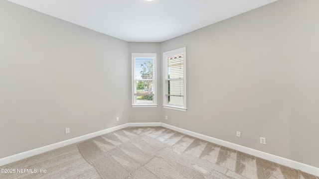 spare room featuring light colored carpet