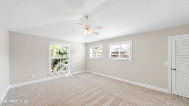 empty room with light carpet, lofted ceiling, and ceiling fan