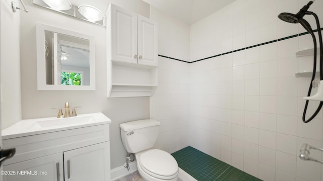 bathroom featuring tiled shower, vanity, and toilet