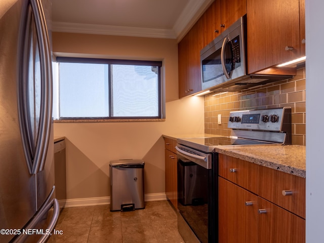 kitchen featuring crown molding, tasteful backsplash, light stone counters, light tile patterned floors, and stainless steel appliances