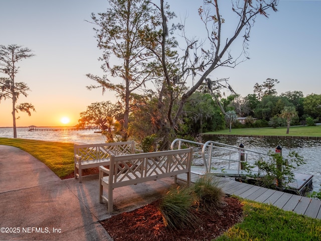 dock area featuring a water view and a lawn