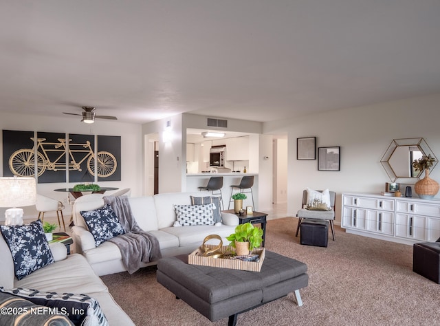 carpeted living room with ceiling fan