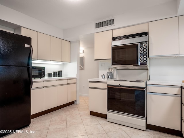 kitchen with light tile patterned floors and black appliances