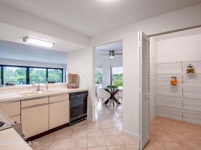 kitchen featuring a healthy amount of sunlight, black dishwasher, sink, and light tile patterned floors