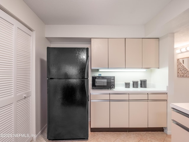 kitchen with light tile patterned floors and black appliances