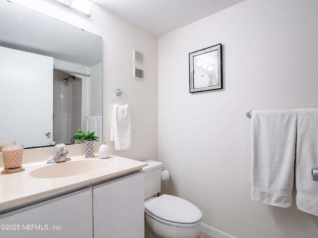 bathroom with vanity, a textured ceiling, toilet, and walk in shower