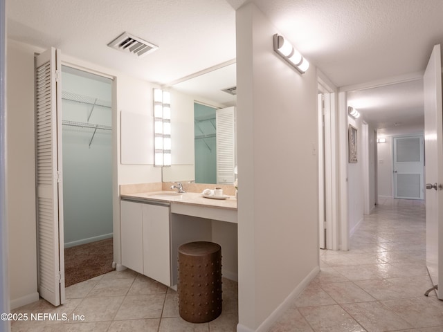 bathroom featuring tile patterned floors, vanity, and a textured ceiling