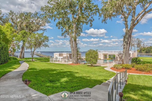 view of home's community featuring a water view and a lawn