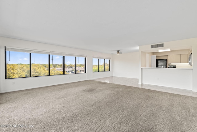 6000 San Jose Blvd Unit 6F, Jacksonville, FL 32217 - unfurnished living room featuring visible vents, tile patterned flooring, carpet, and a ceiling fan