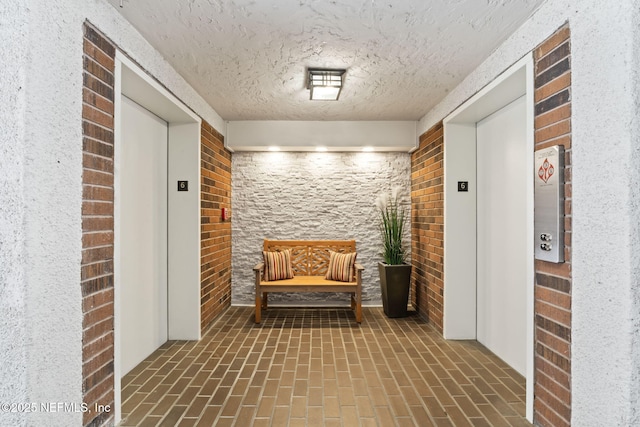 6000 San Jose Blvd Unit 6F, Jacksonville, FL 32217 - interior space with a textured ceiling, brick floor, elevator, and brick wall