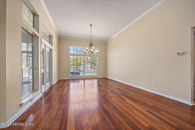 unfurnished dining area featuring crown molding, dark wood-type flooring, a textured ceiling, and an inviting chandelier