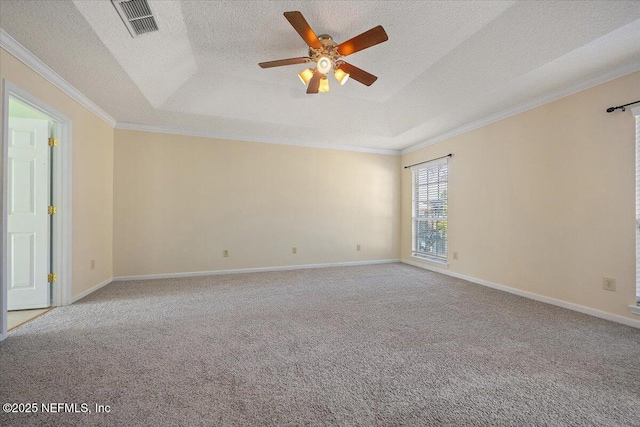 empty room featuring a tray ceiling, ornamental molding, and light colored carpet