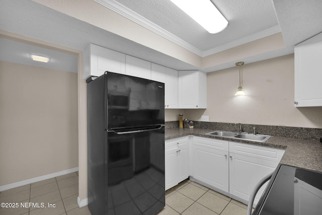 kitchen featuring a sink, range, freestanding refrigerator, dark countertops, and a raised ceiling