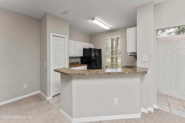 kitchen with sink, white cabinets, light colored carpet, kitchen peninsula, and black refrigerator with ice dispenser