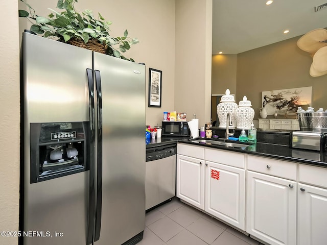 kitchen featuring light tile patterned flooring, appliances with stainless steel finishes, white cabinetry, sink, and kitchen peninsula