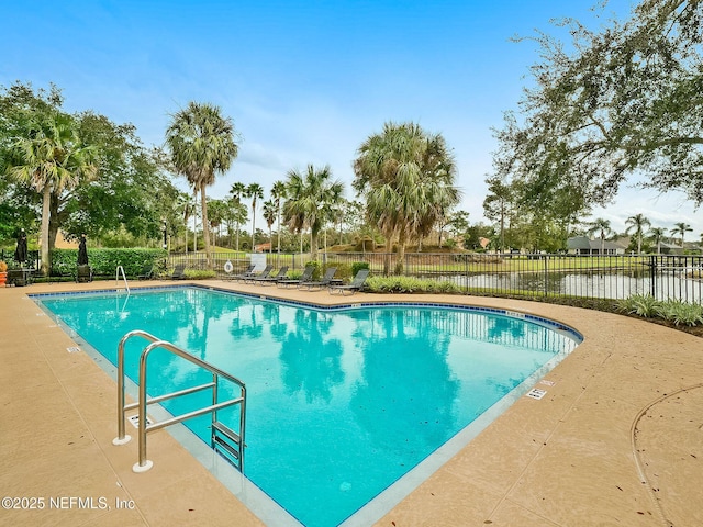 view of swimming pool with a patio area and a water view