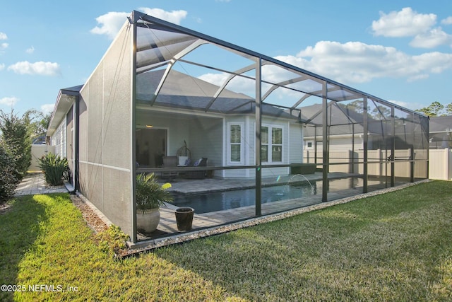 back of property with pool water feature, a yard, glass enclosure, and a patio area