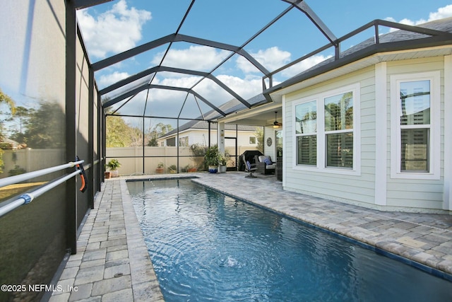 view of swimming pool featuring ceiling fan, a patio, and glass enclosure