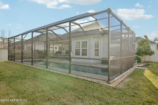 rear view of property with pool water feature, a yard, and glass enclosure