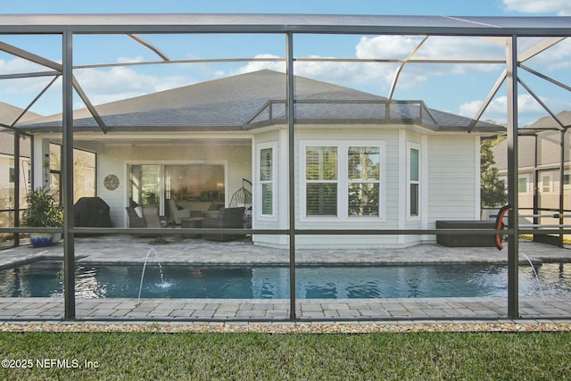 view of swimming pool featuring pool water feature, a lanai, and a patio