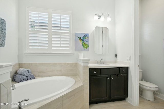 bathroom featuring vanity, toilet, and tiled bath