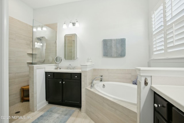 bathroom with vanity and shower with separate bathtub