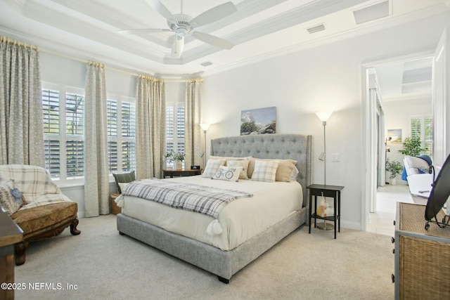 carpeted bedroom featuring a tray ceiling, crown molding, and ceiling fan