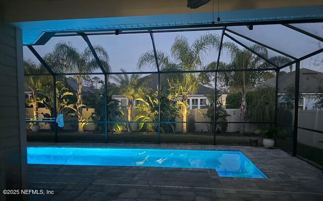 view of swimming pool with glass enclosure and a patio area