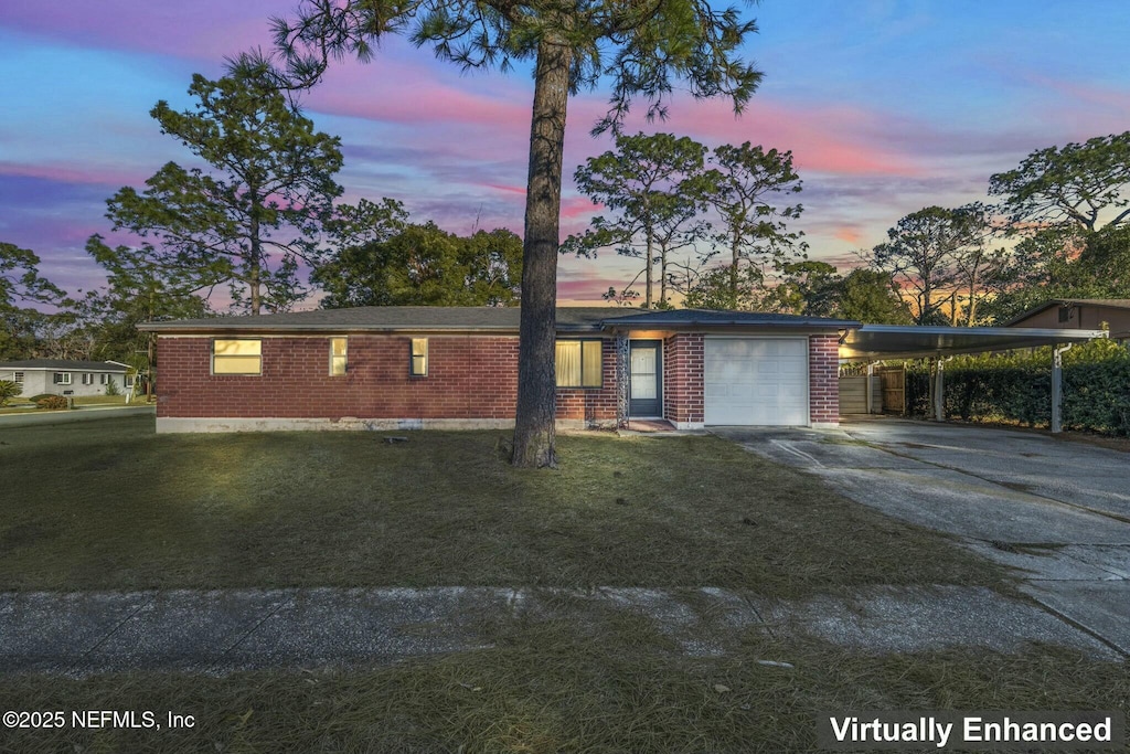 view of front of house featuring a carport, a garage, and a lawn