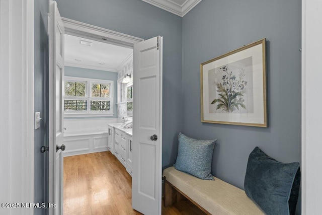 bathroom with vanity, a tub to relax in, crown molding, and wood-type flooring