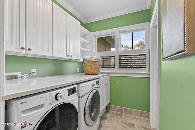 laundry room with ornamental molding, washing machine and dryer, and cabinets