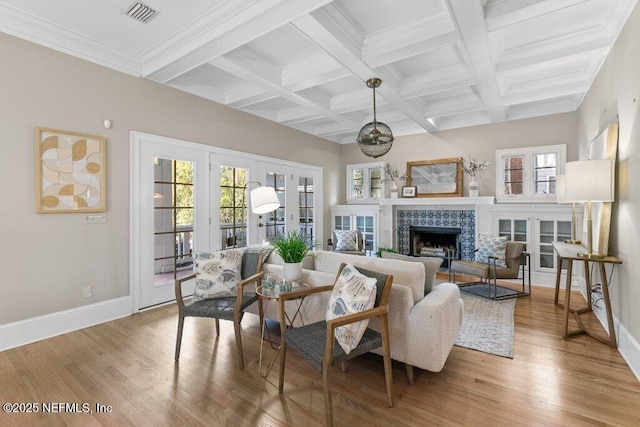 living room featuring beam ceiling, a wealth of natural light, and a tile fireplace