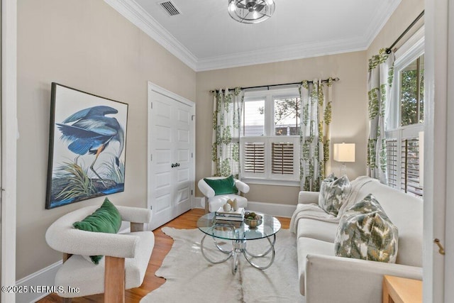 sitting room featuring hardwood / wood-style flooring, crown molding, and a healthy amount of sunlight