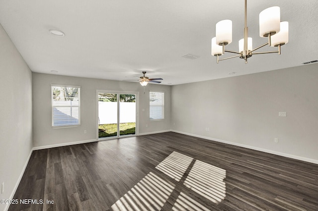 empty room featuring dark hardwood / wood-style flooring and ceiling fan with notable chandelier