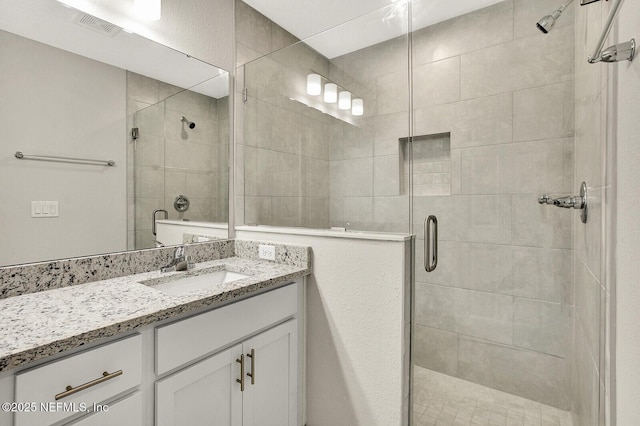 bathroom with a shower with door and vanity