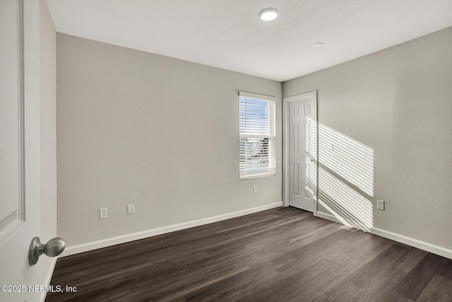 unfurnished room featuring dark wood-type flooring