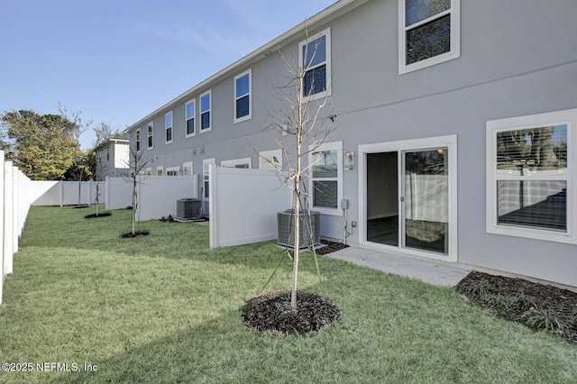 rear view of house featuring cooling unit and a lawn