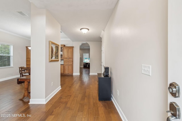 hallway with crown molding and dark hardwood / wood-style floors