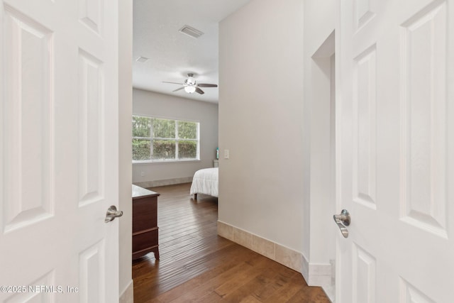 corridor featuring wood-type flooring and a textured ceiling