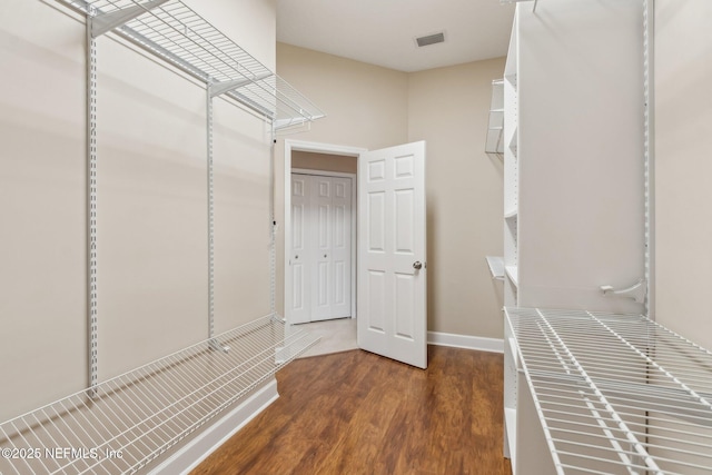 spacious closet featuring dark hardwood / wood-style flooring