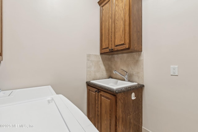 laundry area featuring cabinets, sink, and washer and clothes dryer