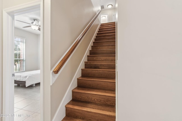 stairway with ceiling fan and tile patterned floors